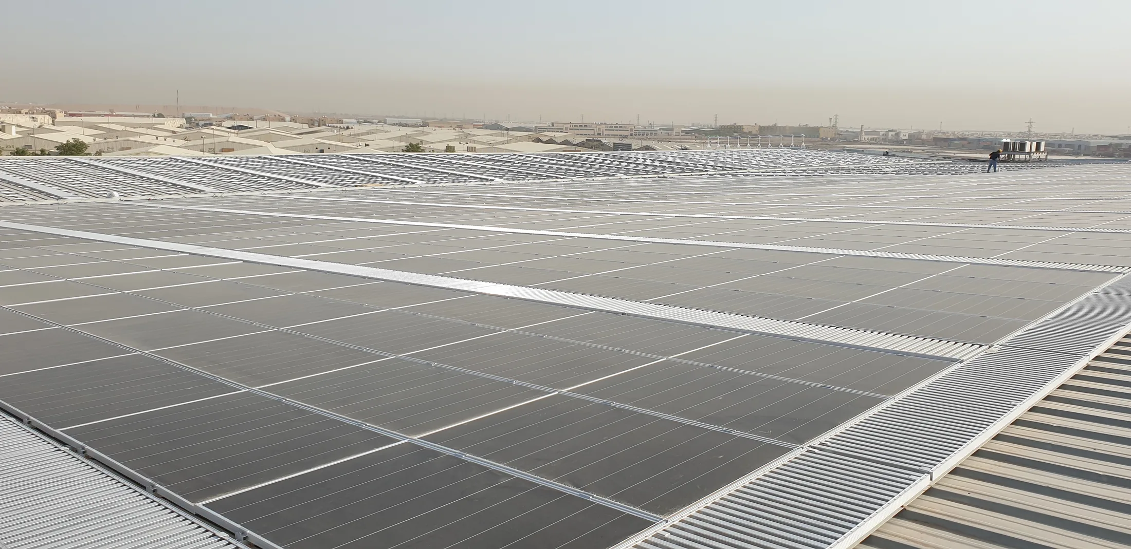 Utility-scale rooftop solar array over a Riyadh industrial complex